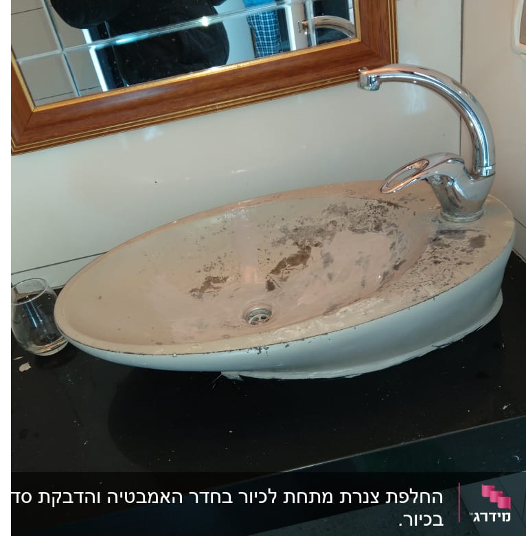 כיור מלוכלך עם ברז מתכת על משטח שחור